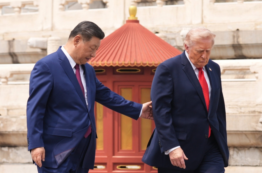 President Donald Trump, right, is assisted by Chinese President Xi Jinping at the Temple of Heaven on Thursday May 14, 2026, in Beijing. (AP Photo/Mark Schiefelbein)