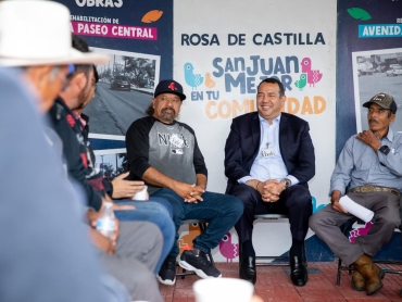 Mesa de atención municipal instalada en una comunidad rural con habitantes entregando solicitudes, sin rostros identificables