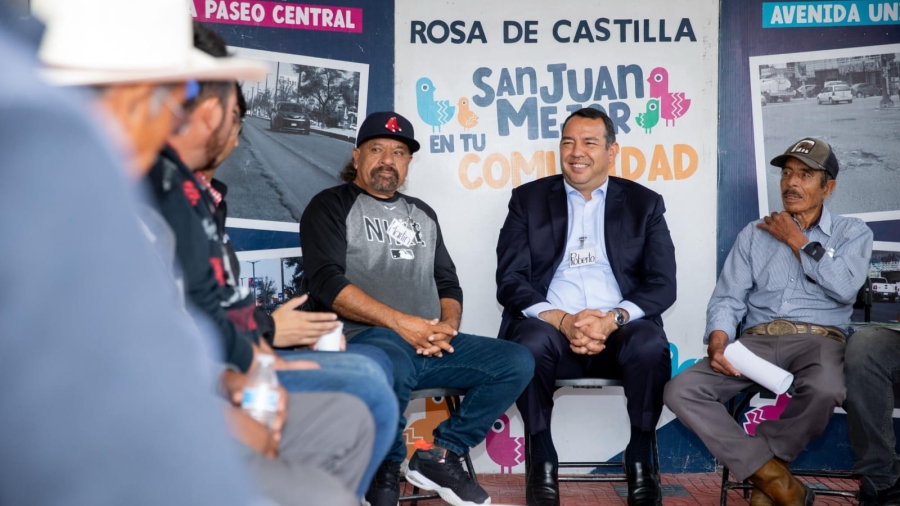 Mesa de atención municipal instalada en una comunidad rural con habitantes entregando solicitudes, sin rostros identificables