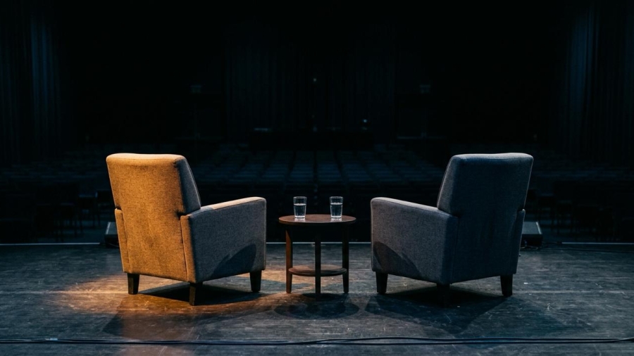 Silla vacía en un escenario de conferencias con micrófono, en referencia a la ausencia de Peter Thiel en un foro en Buenos Aires.