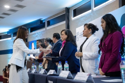 La Rectora Amaya al momento de entregar la medalla al merito estudiantil a una estudiante