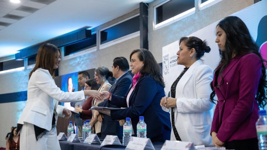 La Rectora Amaya al momento de entregar la medalla al merito estudiantil a una estudiante