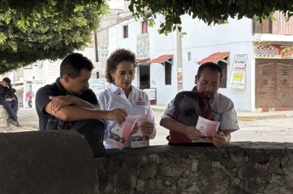 La Diputada Adriana Argaluza con 2 ciudadanos a quienes les explica sus actividades legislativas